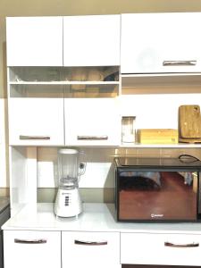a kitchen with white cabinets and a blender on a counter at Florencia Lodgement in Lima