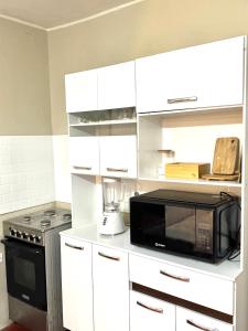 a kitchen with white cabinets and a microwave at Florencia Lodgement in Lima +5 photos