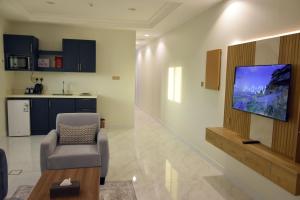 a living room with a chair and a tv on a wall at غيمة in Hail