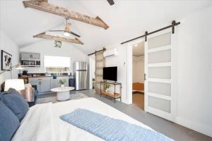 a living room with a blue couch and a kitchen at Luxe King Studio Near AMI! Beach Gear & Fast WiFi in Bradenton