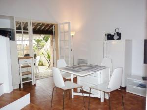 une salle à manger avec une table et des chaises blanches dans l'établissement Charmant mas 4 personnes avec piscine et parking à La Croix-Valmer - FR-1-726-60, à La Croix-Valmer