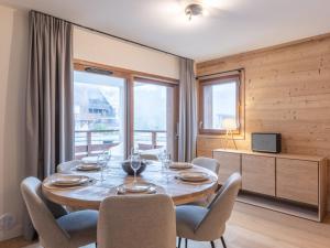 a dining room with a table and chairs and a window at Appartement neuf 4 ch retour ski, garage, 8 pers. - FR-1-645-93 in L'Alpe-d'Huez
