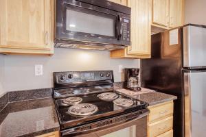 a kitchen with a stove and a microwave at CozySuites at Current the Banks gym pool 01 in Cincinnati
