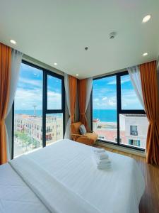 a bedroom with a large bed and a large window at Hayha Apartment by Haus Hospitality in Phu Quoc