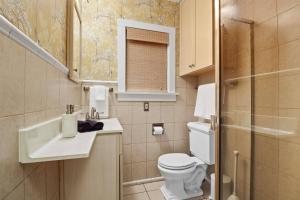 a small bathroom with a toilet and a sink at 1920s Cottage | Hot Tub | Game Room | Fire Pit in Rockford +26 photos