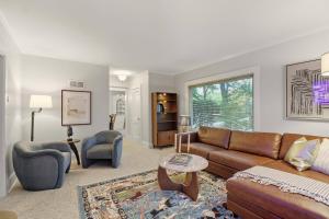 a living room with a brown couch and chairs at 1920s Cottage | Hot Tub | Game Room | Fire Pit in Rockford