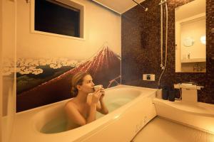 東京にあるWANOYADO Tokyo - Modern Japanese House near Shinjuku & Shibuyaの浴槽に座って飲んでいる女性 +53枚の写真