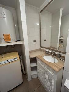 a bathroom with a sink and a large mirror at Apartamento cerca de Casino Marina del Sol en Talcahuano in Talcahuano
