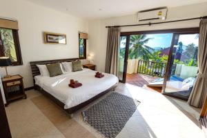 a bedroom with a bed with teddy bears on it at Maenam Hills Samui in Koh Samui  +81 photos