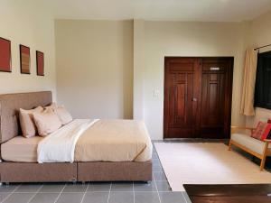 a bedroom with a bed and a couch and a door at Wichouda Cottage - Self Check-in in Chiang Dao +46 photos