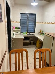 a kitchen with a counter and two chairs in it at RumahCheMatsunami in Tanah Rata