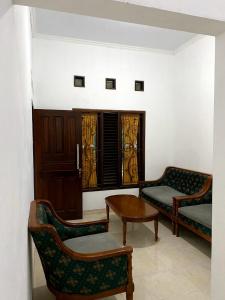 a living room with two chairs and a table at Cosinus Purwosari in Kejayan