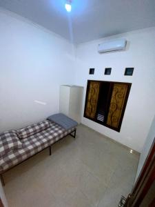 a room with a bench in a room with a window at Cosinus Purwosari in Kejayan