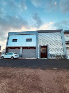 a blue building with a car parked in front of it at Hotel Sunrise in Ādkot