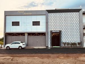 a white car parked in front of a building at Hotel Sunrise in Ādkot +6 photos