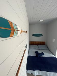 Una cama pequeña en una habitación pequeña con un barco en la pared. en Inn Nature Pousada, en Palhoça
