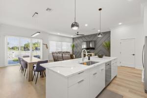 a kitchen with a white counter and a dining room at NEW! Columbus Cove - Newly Built, Luxurious Home in Heart of Tampa in Tampa