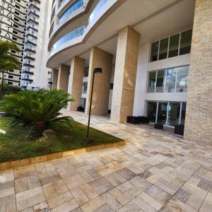 a large building with a courtyard in front of it at Encontro marcado in Praia Grande