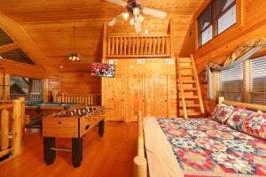 a bedroom with a bed and a pool table in a cabin at Romancing - 2 BR High In The Mountains in Sevierville +13 photos