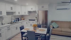 a kitchen with white cabinets and a table and a couch at Country Blue Getaway by the Ranch Fields in Auburndale