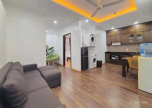 a living room with a couch and a kitchen at Moon Hotel Apt Phạm Tuấn Tài in Hanoi