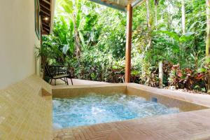 a hot tub in the middle of a patio at Casa Merlin Yoga & Welness Hotel in Puerto Viejo +31 photos