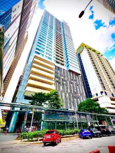 a red car parked in front of a tall building at Luxury Mercu Summer Suites KLCC By JT in Kuala Lumpur