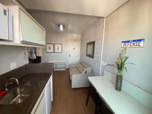 Una cocina con fregadero y una sala de estar. en Apartamento 1801no Hotel Eldorado AP - Particular, en Contagem