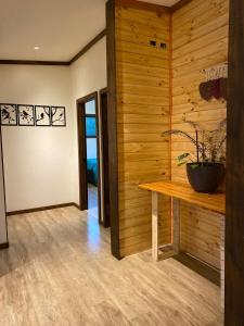 a room with a wooden wall with a bench and a plant at Aldea Molco Arrayan in Villarrica