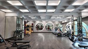 a gym with treadmills and ellipticals and a person in the gym at Hayha Apartment by Haus Hospitality in Phu Quoc