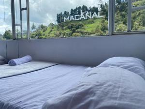 a bedroom with a bed and a large window at El Oasis Hotel Hospedaje in Macanal