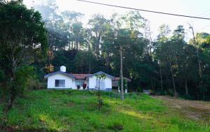 a small white house in the middle of a field at Green Echoes by Tripture - Holiday Villas in Coorg in Cherambane +9 photos