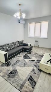 un salon avec un canapé et un tapis dans l'établissement ЖК Асель, à Atyraū