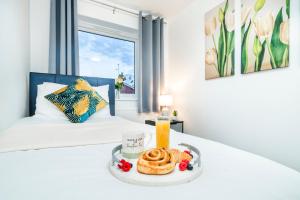 a hotel room with a bed with a tray of food at Monmouth House Aylesbury Premier Quality Accommodation For Larger Families Contractors And Professionals Sleeps Up to 6 Guests in Buckinghamshire