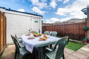 a patio table with chairs and food on it at Monmouth House Aylesbury Premier Quality Accommodation For Larger Families Contractors And Professionals Sleeps Up to 6 Guests in Buckinghamshire