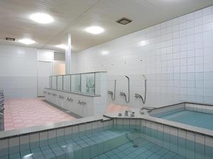 a bathroom with a swimming pool and a tub at Hotel SP Haruno in Kochi