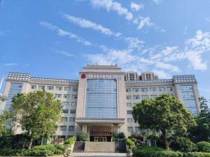 a large building with trees in front of it at Centenio International Hotel in Foshan