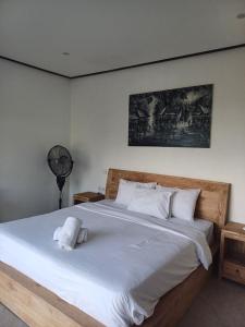Un dormitorio con una cama con un animal de peluche encima. en Green Bowl Bali Guest house, en Ungasan