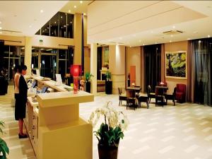 a woman standing at a counter in a hotel lobby at Huangshan Scholars Conference Hotel in Huangshan