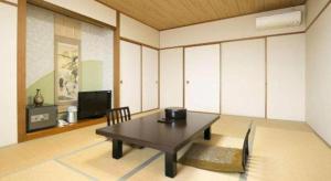 a living room with a table and a tv at Hotel Kaijyokan in Tosashimizu +9 photos