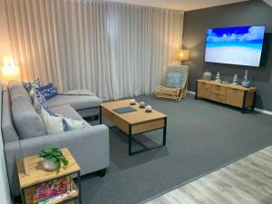 ein Wohnzimmer mit Couch und Flachbildfernseher in der Unterkunft Corrigans Beach View Apartment 211 in Batehaven