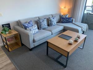 ein Wohnzimmer mit einer Couch und einem Couchtisch in der Unterkunft Corrigans Beach View Apartment 211 in Batehaven + 34 Fotos