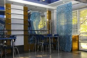 ドニプロジェルジンシクにあるZolotie Peskiの青い椅子、テーブル、窓のあるレストラン