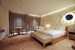 Un dormitorio con una cama grande y una mesa y sillas. en Hoi An Mona Royal Hotel, en Hà My Tây (2)