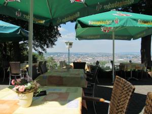 einen Tisch und Stühle mit grünen Sonnenschirmen in einem Restaurant in der Unterkunft Hotel Rheinkrone in Koblenz