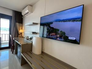 a living room with a large flat screen tv on the wall at Siam Triangle Hotel Chiang Sean in Chiang Saen