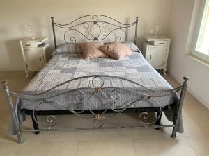 a bedroom with a metal bed with two night stands at Agriturismo Corte Bonetti - Appartamento Il Salice in Pescantina