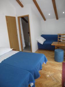 a bedroom with a blue bed and a blue couch at Apartman Kristina, studio i soba in Primošten
