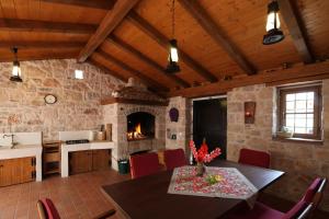 eine Küche und ein Esszimmer mit einem Tisch und einem Kamin in der Unterkunft Villa Vallis in Bribir