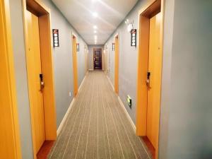 a hallway with orange doors and a long corridor at Shell Hotel Jiangsu Taizhou Hailing District Taizhou Avenue in Sixiang +7 photos